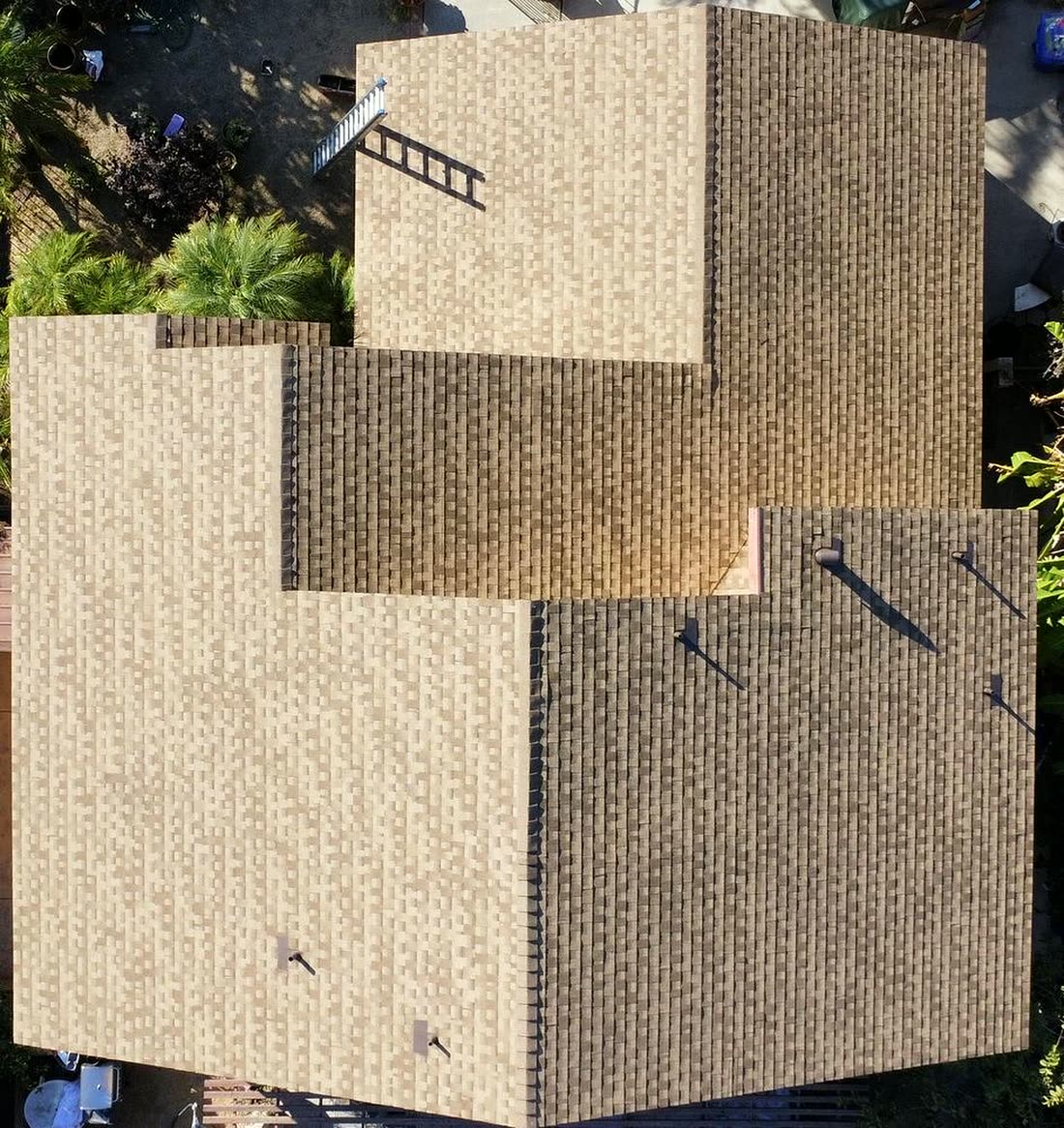 Aerial drone view of a completed multi-plane asphalt shingle roof