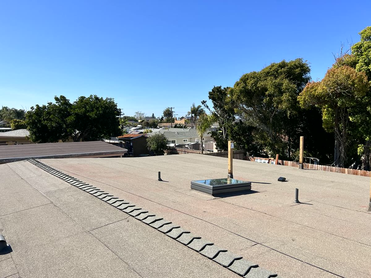 Completed flat low-slope commercial roof with fresh sealant and clean drainage detailing